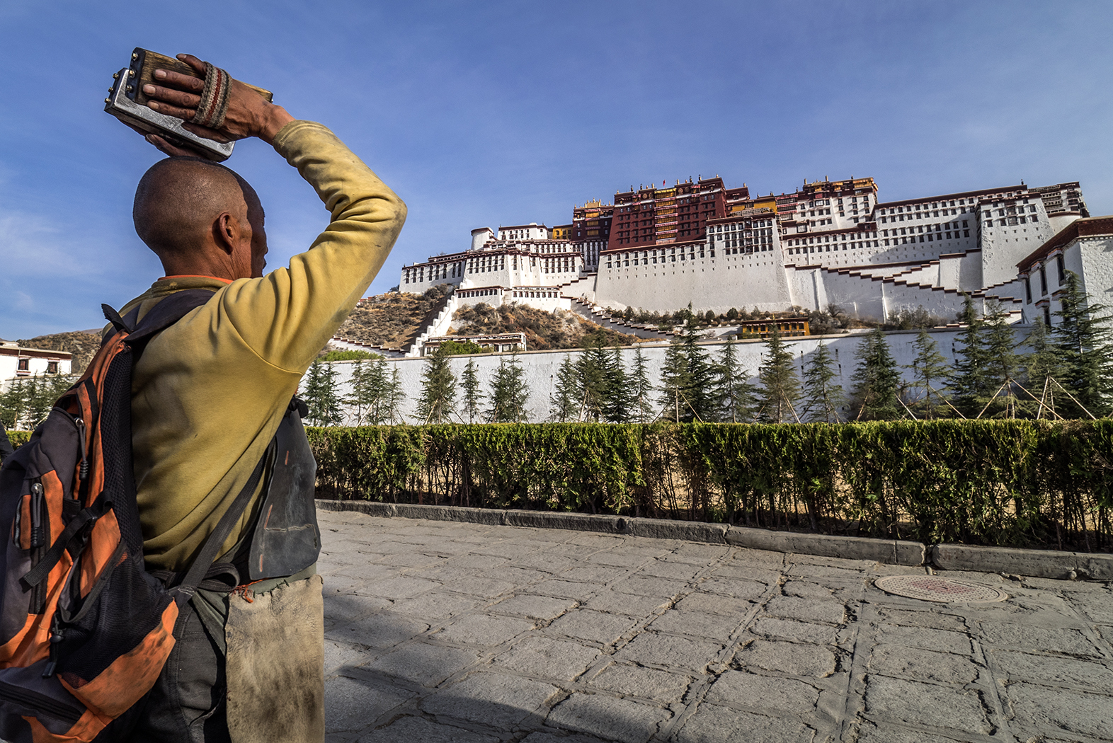 Lhasa, Tibet, a pilgrim honors Poltala Palace by prostrating himself a couple of hundred times in front of the sacred building.